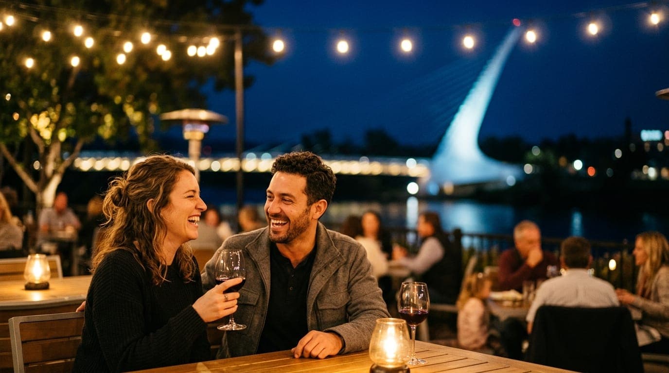 An 85mm portrait captures a couple laughing on the Mosaic patio at night. Warm tungsten lights illuminate their wine glass...
