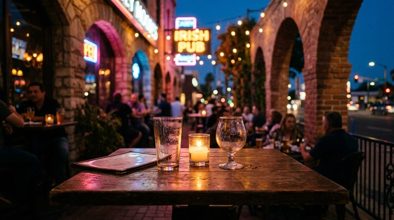 Centered 24mm wide-angle shot of a candle-lit table at Casey Moore’s patio. Two empty craft beer glasses sit beside a diml...