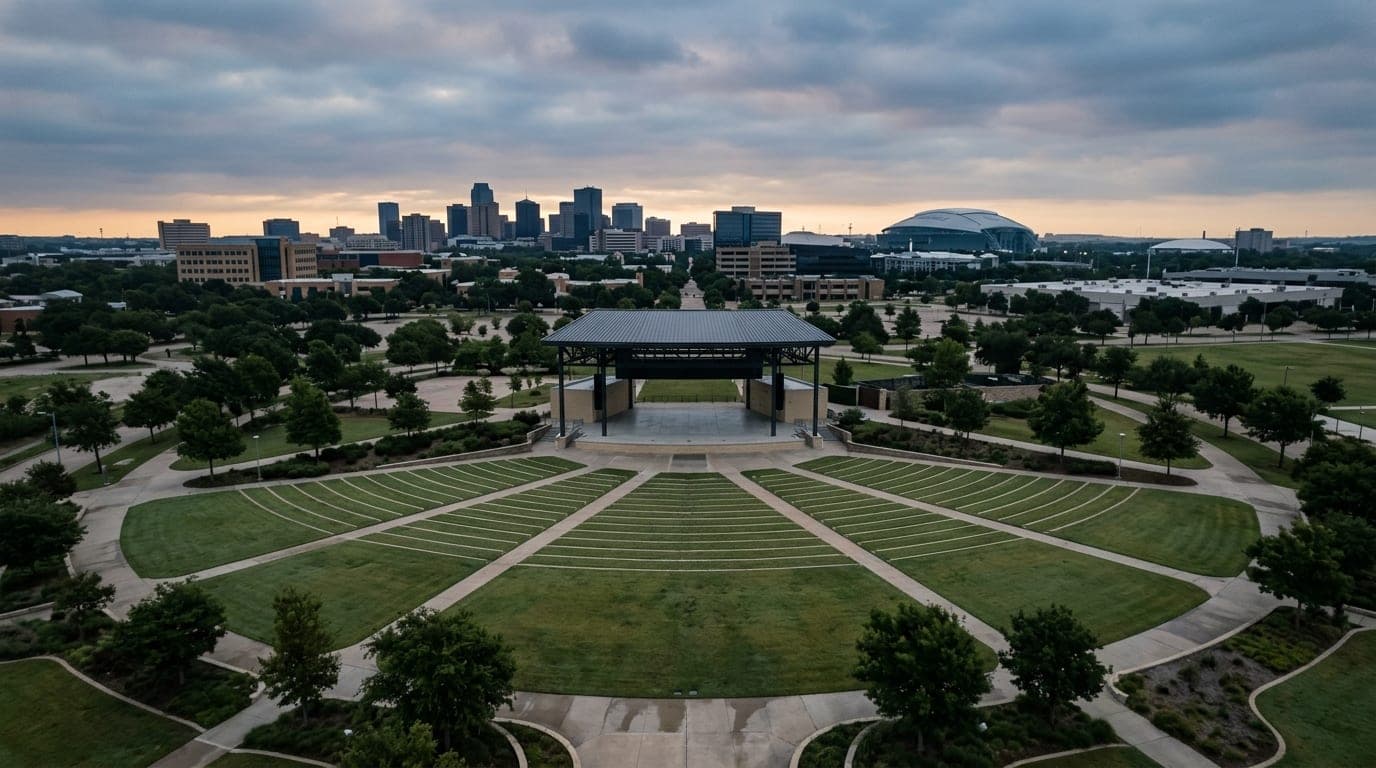 An overhead 24mm flat-lay view of the Levitt Pavilion’s stage and empty lawn at dawn under overcast skies, capturing the s...