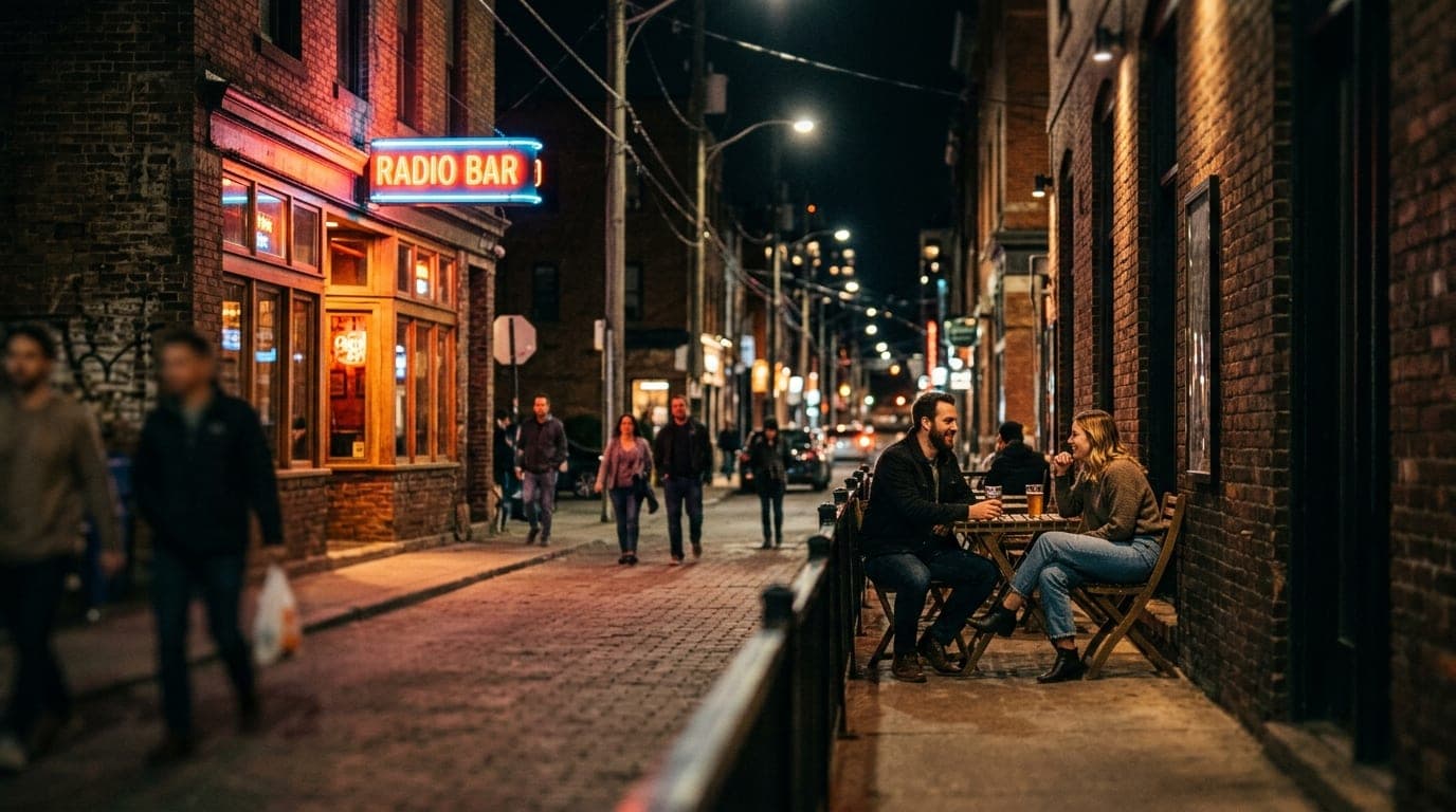Wide establishing shot of Radio Bar’s glowing neon exterior at night. Tilt-shift focus highlights a couple in casual attir...