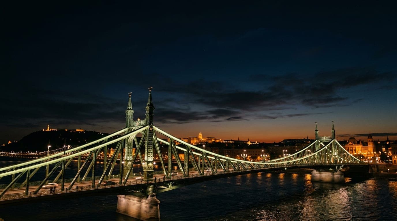 A low-angle, 50mm shot of the Liberty Bridge at midnight, bathed in soft ambient city glow. The sleek, curved structure oc...