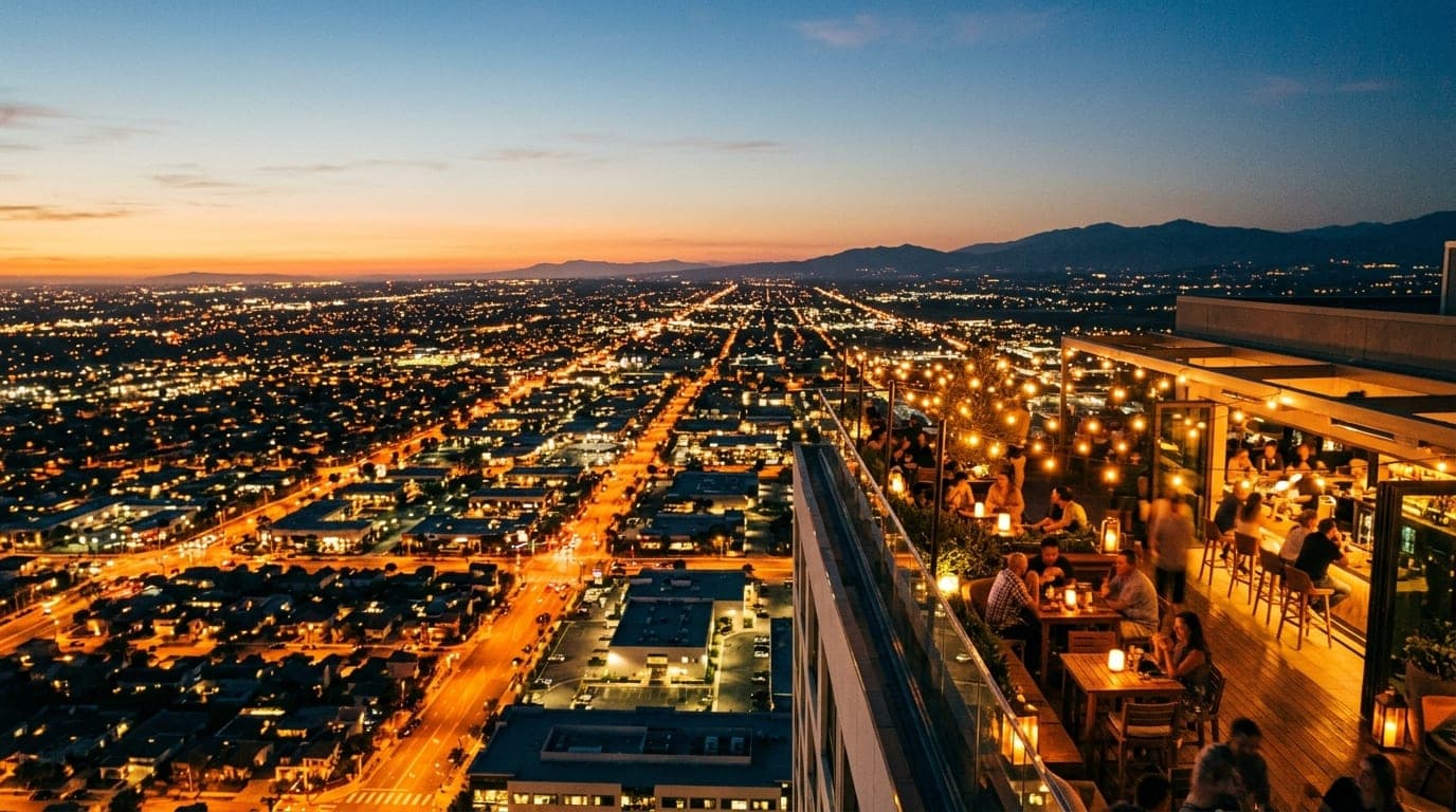 A wide 35mm documentary shot at dusk captures the glowing, amber-lit Hive Honey rooftop terrace, positioned in the right t...